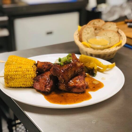 Steak s kukuřicí a bramborovými hranolky na talíři